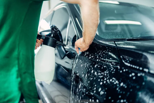 Adam arabanın üstüne sabunlu su dağıtırken — Stok fotoğraf