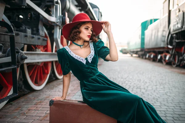 女人坐在行李箱逼平蒸汽火车上 — 图库照片