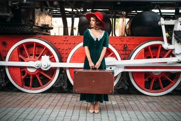 Mujer con maleta contra locomotora de vapor — Foto de Stock