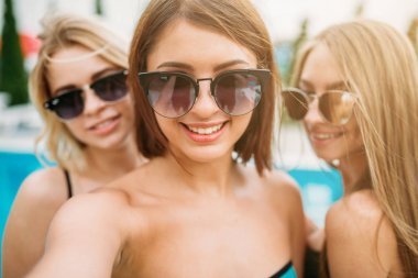 Havuz başı, üç mutlu genç kadın