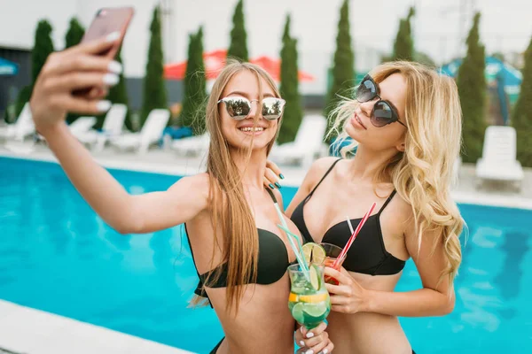Dua wanita muda yang bahagia di tepi kolam renang — Stok Foto