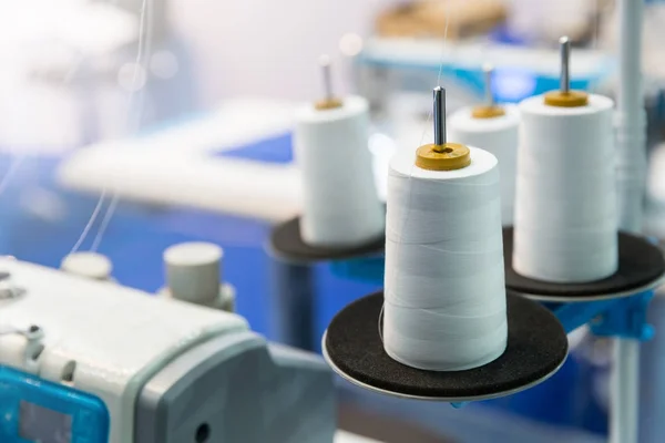 Катушки нитей на швейной машинке — стоковое фото