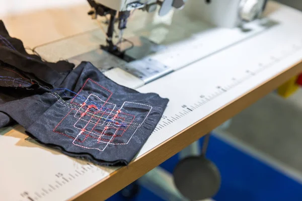 Professionelle Nähmaschine und schwarzes Textil — Stockfoto