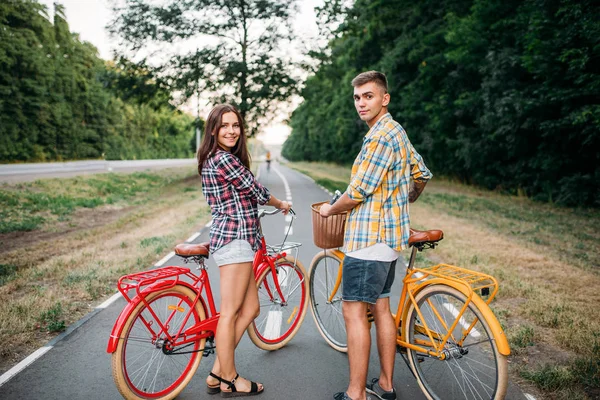 Feliz hombre y mujer posando con bicicletas — Foto de Stock