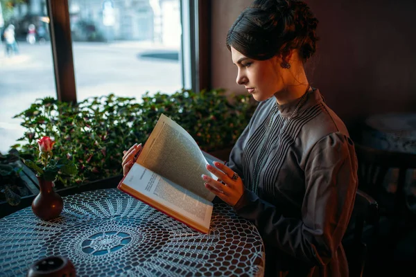 Vrouw in retro jurk leesboek — Stockfoto