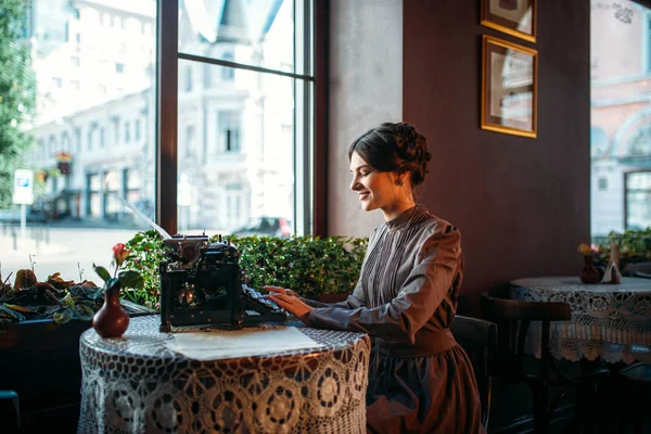 Jonge vrouw met antieke typemachine — Stockfoto