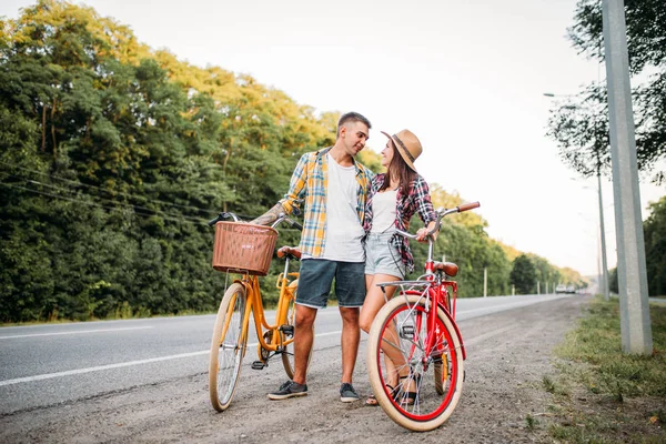 Homem feliz e mulher posando com bicicletas — Fotografia de Stock