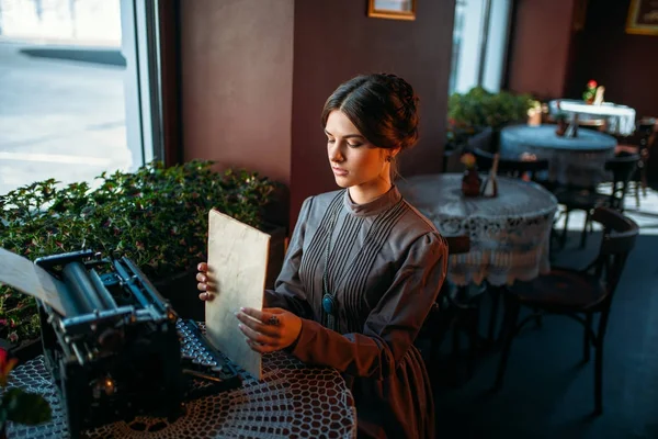 Giovane donna con macchina da scrivere antica — Foto Stock