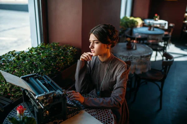 Mujer joven con máquina de escribir antigua —  Fotos de Stock