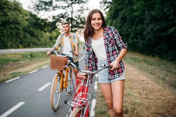 Zadowolony mężczyzna i kobieta stwarzających z rowerów — Zdjęcie stockowe