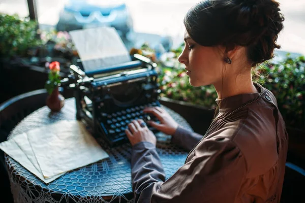 Jovem com máquina de escrever antiga — Fotografia de Stock