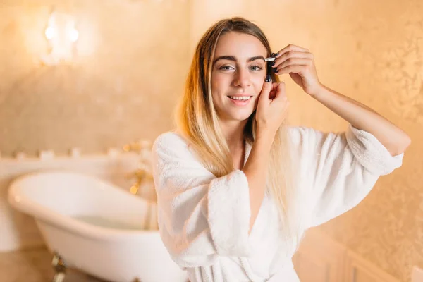 Frau im weißen Bademantel beim Make-up — Stockfoto