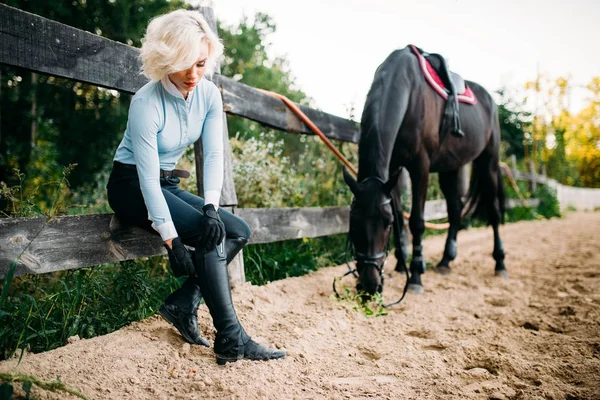 Jockey posant avec cheval à hippodrome — Photo