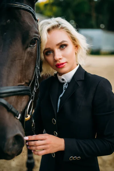 Ženské žokej pózuje s koněm — Stock fotografie