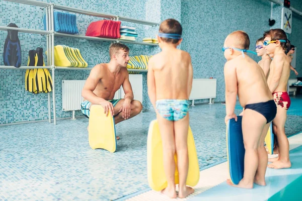 Instructeur formant les enfants dans la piscine — Photo