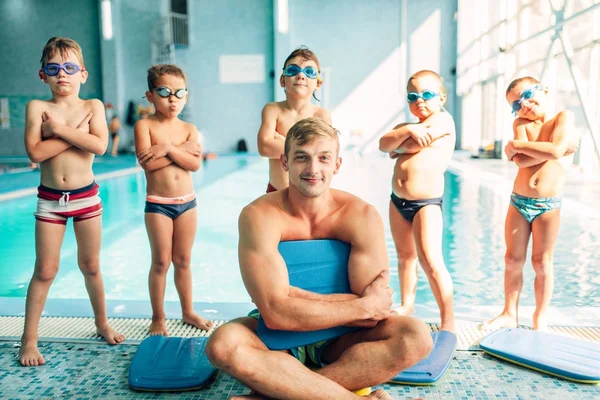 Instrutor e meninos posando perto da piscina — Fotografia de Stock