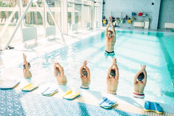 Ausbilder bildet Jungen im Pool aus — Stockfoto