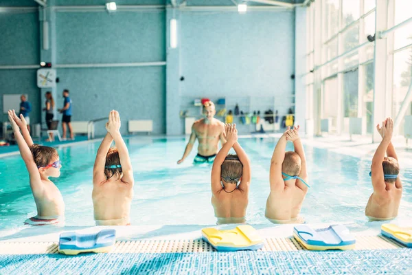 Instructor entrenamiento chicos en piscina — Foto de Stock