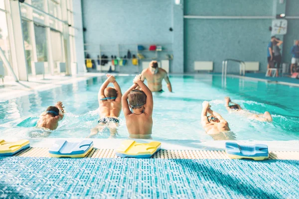 Instrutor de formação meninos na piscina — Fotografia de Stock