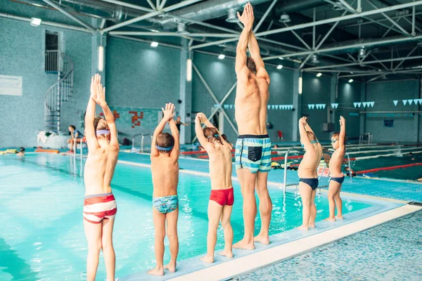 Instrutor de formação de crianças na piscina — Fotografia de Stock