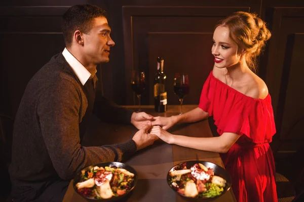 年轻的情侣在餐厅 浪漫的约会 典雅的妇女在红色礼服和英俊的人用餐 — 图库照片