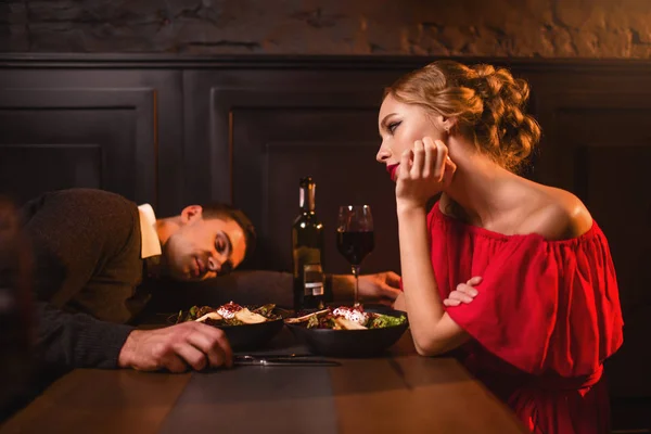 Opilý muž spí u stolu proti žena — Stock fotografie