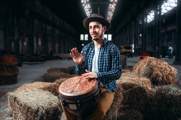 アフリカ木製ドラム 背景に工場を再生する若い男性ドラマー ジャンベ パーカッション楽器 — ストック写真