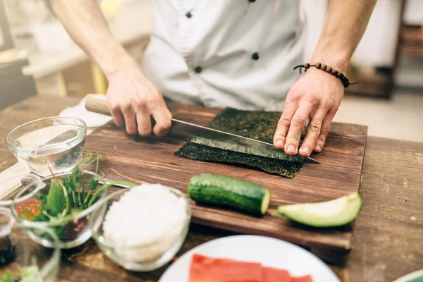 男厨师做寿司 在木桌上切紫菜 传统日本料理 — 图库照片