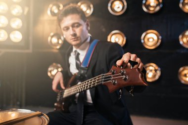 arka plan ışığı ile bas gitar, rock grubu, sahne alanı üzerinde oynarken gitarist