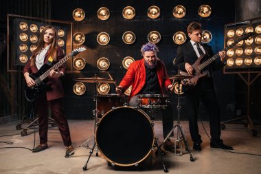 müzisyenler sahne ışıkları, retro tarzı, gitaristler ve davulcu, rock grubu ile takım elbiseli