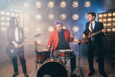müzisyenler sahne ışıkları, retro tarzı, gitaristler ve davulcu, rock grubu ile takım elbiseli