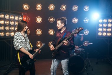 Elektrik ve bas gitar, arka plan ışığı ile sahne oynarken gitaristler