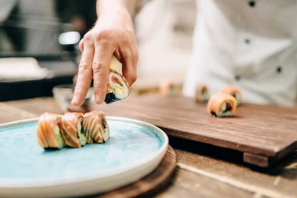 Male Cook Making Sushi Roll Wooden Table Putting Roll Plate — Stock Photo, Image