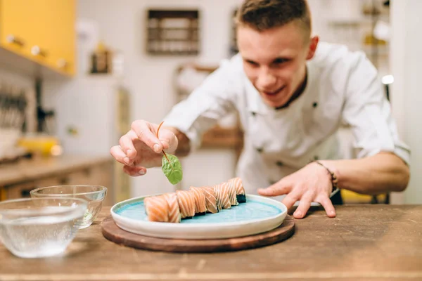 Lachende Mannelijke Cook Decoreren Sushi Roll Blauw Bord Traditionele Japanse — Stockfoto