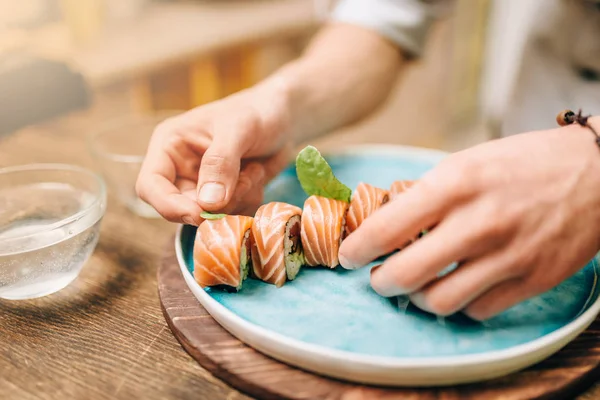 Erkek Aşçı Yapım Suşi Roll Ahşap Masa Roll Mavi Plaka — Stok fotoğraf