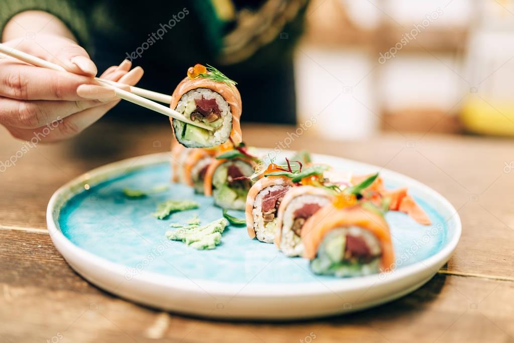 man eating sushi with chopsticks