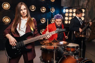 müzisyenler sahne ışıkları, retro tarzı, gitaristler ve davulcu, rock grubu ile takım elbiseli