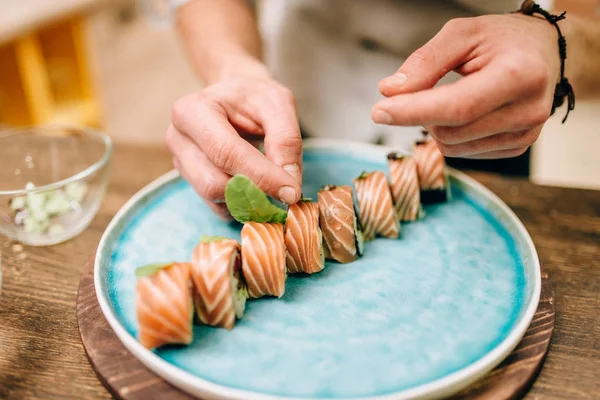 Мужчина Повар Украшающий Суши Ролл Голубой Тарелке Традиционная Японская Кухня — стоковое фото