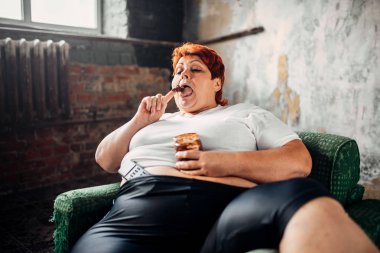 koltukta oturan ve tatlı çörek, tembellik, obezite ve sağlıksız gıda kavramı yemek yeme kadın kilolu