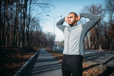 erkek sporcu sonbahar parkta çalıştırmadan önce ısınma