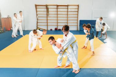 boys in kimono practicing martial art in sport gym  clipart