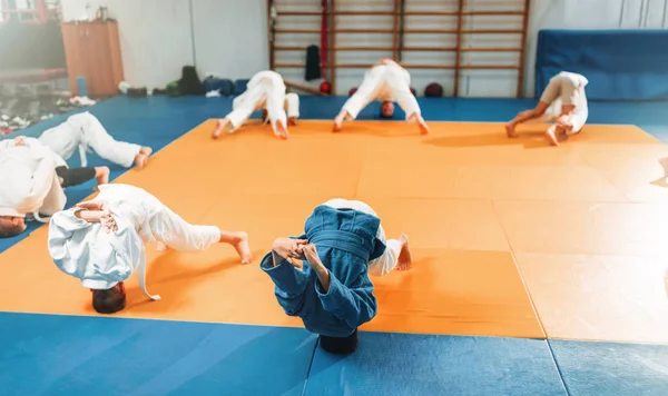 boys in kimono practicing martial art in sport gym