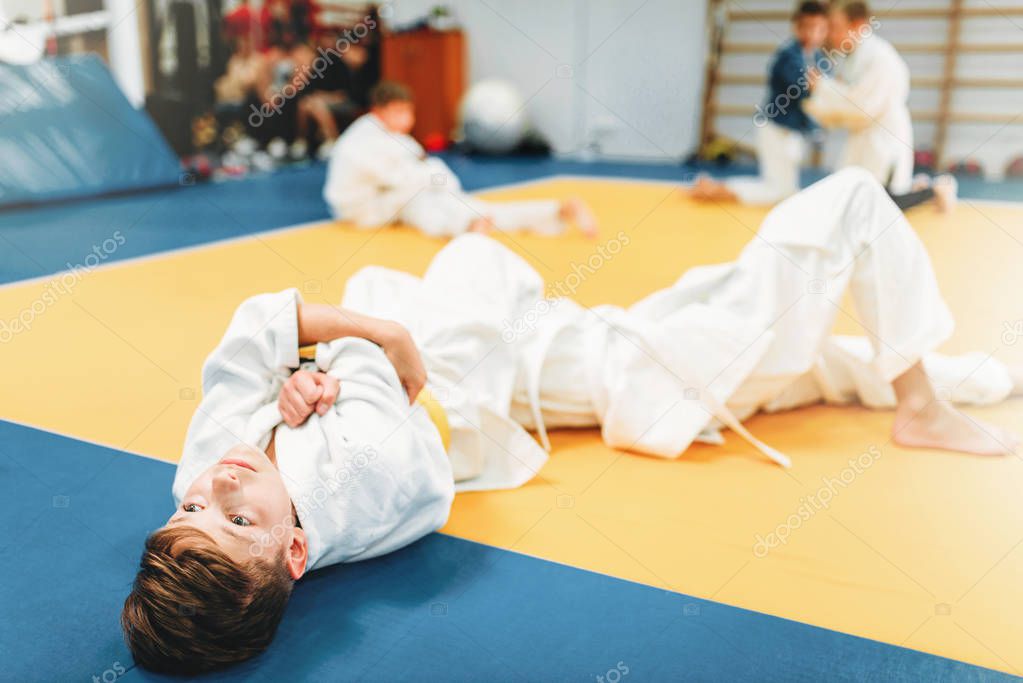  boys in kimono practicing martial art in sport gym 