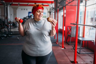 fast food ve halter eller, motivasyon, spor olarak zor çalışma ile şişman kadın