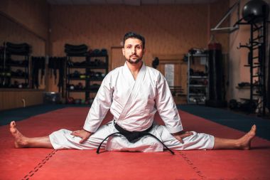 siyah kemer germe egzersiz, spor salonunda eğitim karate yapmak ile beyaz kimono dövüşçü