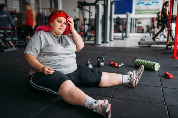 疲惫的超重妇女在健身房的地板上选址 — 图库照片