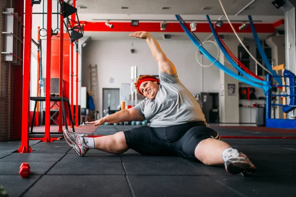 fat woman exercising on floor, workout in gym