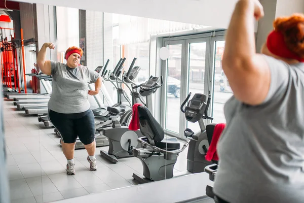 在健身房对镜子的肥胖的出汗妇女训练 — 图库照片