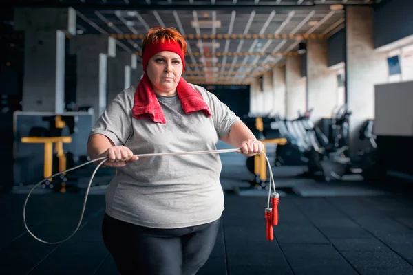 在健身房里抱着跳绳的胖汗女人 — 图库照片