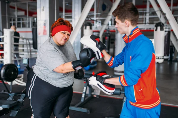 Υπέρβαρη Γυναίκα Στα Γάντια Πυγμαχίας Εκπαιδευτή Στο Γυμναστήριο — Φωτογραφία Αρχείου